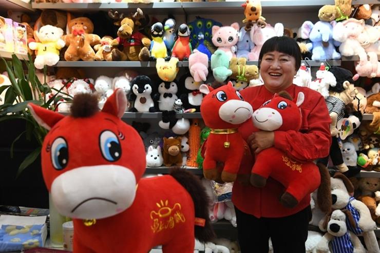 Shop owner Zhang Huoqing showcases the trending “Crying Horse” plush toy at the Yiwu International Trade City in Zhejiang Province on January 13, 2026